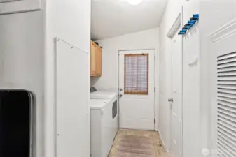 Dedicated laundry space with overhead cabinetry and exterior access.