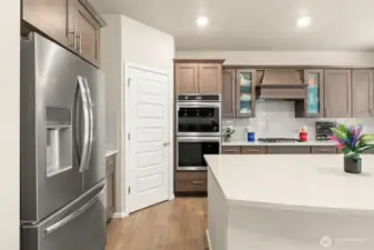 A closer look at the gourmet kitchen reveals a sleek stainless steel French-door fridge, double wall ovens, and a walk-in pantry—thoughtfully designed to inspire your inner chef.