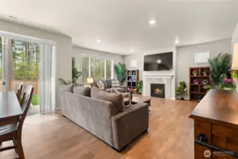 Cozy up in the inviting living room, featuring a gas fireplace, large windows for natural light, and direct access to the backyard—ideal for relaxing evenings or weekend gatherings.