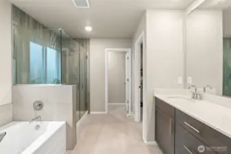 The spa-inspired ensuite bath features a luxurious soaking tub, oversized walk-in shower with floor-to-ceiling tile, dual-sink vanity, and access to a spacious walk-in closet—your private retreat for rest and relaxation.