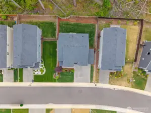 Bird’s-eye view of the property reveals a generous, fully fenced backyard backing to a greenbelt—providing added privacy and a peaceful natural buffer rarely found in suburban living.