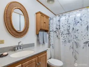 Full guest bathroom with shower-tub combo and updated finishes.