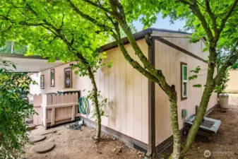 Back corner of the home framed by mature trees for added privacy.