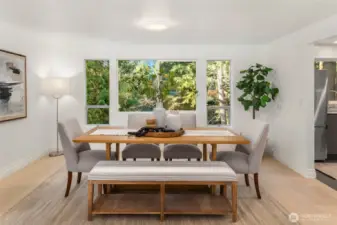 Dining room adjacent to the kitchen, with views of the lush, green backyard.