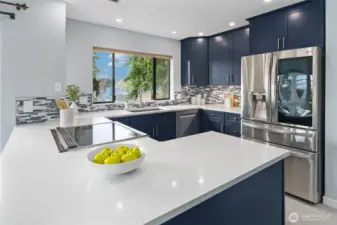New kitchen with beautiful navy cabinets, quartz, designer tile, induction range, special vent hood flush to the ceiling and coffee bar!