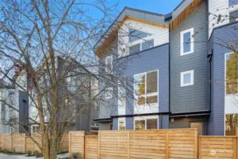 A picturesque angle showcasing the seamless design of this home. Nestled in a tree-lined community, it offers privacy and serenity with a modern flair.