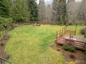 Large fenced back yard with fire pit