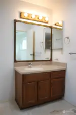 Granite tiled floors in primary suite bathroom with Corian counter top and solar tube for natural lighting.