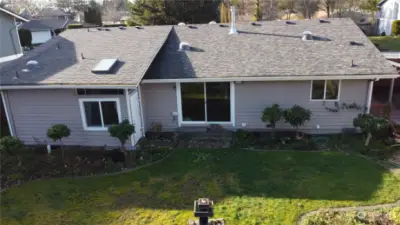 Back of the house showing the atrium, back slider off great room, the kitchen window and the side covered deck.  Large, fully fenced backyard.  Good roof, gutters, and six solar tubes for natural light throughout home.