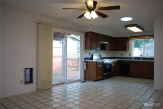 Tiled dining area and kitchen with a slider leading to a cover side deck.  Ceiling fan and solar tube.