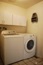 Utility room off of dining area with passage to the garage.