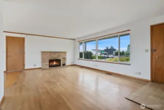 Living room with original hardwood floors, tile entry and large picture window. Shown here without the virtual staging.