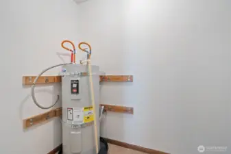 Hall utility room with storage and hot water tank.