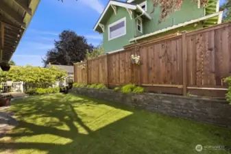The yard is framed by a canopy of mature trees, adding both privacy and that lush, Pacific Northwest charm buyers love.
