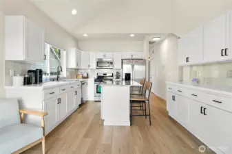 The kitchen is the true heart of this home, featuring quartz counters, newly painted cabinetry with updated hardware, and a striking glass backsplash that adds a touch of sparkle.