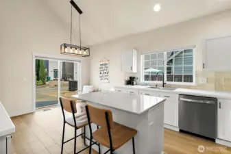 The kitchen is anchored by a versatile island designed for seating, prepping, and ample storage, blending style with convenience.
