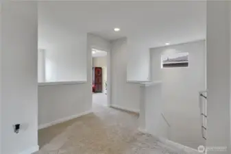 Upstairs looking from primary room, towards 3rd bedroom and stairs.