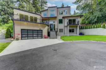 Modern Architectural Design & Elevated Style. Surrounded by Towering Trees. 819 SF Garage with Glass Door. Grassy areas and Pathways leading to the Back Courtyard.
