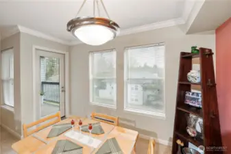 This dining space is bathed in natural light from oversized windows and a glass door leading to your private balcony—ideal for morning coffee or dining alfresco. The open layout offers relaxing views of the community green space while maintaining an intimate, welcoming vibe indoors.