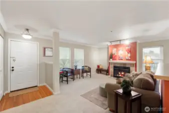 This wide-angle view shows off the thoughtful layout, with open sightlines connecting the living room, dining space, and kitchen. Subtle architectural touches like half-walls, crown molding, and column accents add character and definition while maintaining an airy, connected feel. Ideal for entertaining or everyday comfort.