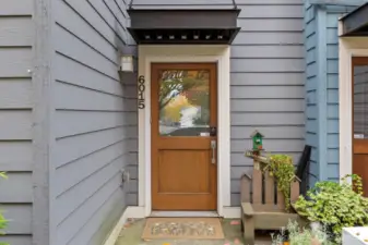 Welcoming entry with wood-accented door and covered stoop.