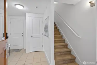 Bright tiled entryway with coat closet and convenient access to the two-car garage. Freshly painted interior with neutral tones and carpeted stairs leading to the main level.
