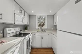 The kitchen is located right off the dining room with a window to the tall lilac that blooms profusely in spring.