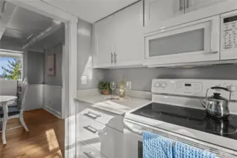 A full set of appliances - oven/range, dishwasher, refrigerator/freezer, and microwave—complete the kitchen.