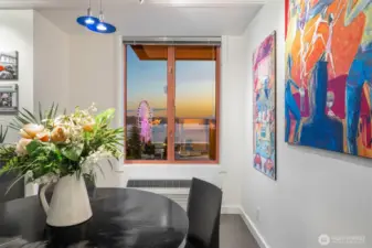 Dining area with artwork-lined walls, perfectly positioned to capture illuminated views of Elliott Bay and the Seattle Great Wheel!