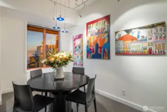 Dining area accented by artwork-lined walls and designer lighting.