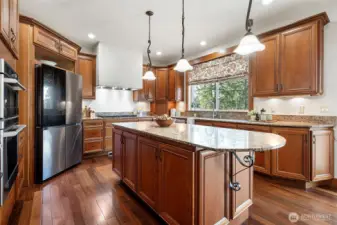 Chef's kitchen with a newer Samsung refrigerator, GE Cafe built-in oven/microwave combo unit and five burner cooktop.