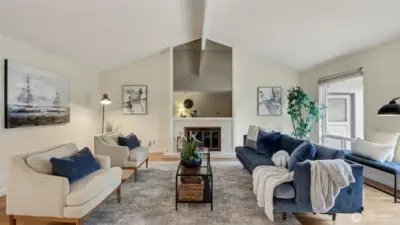 Vaulted ceilings and a central fireplace make this living room the perfect place to unwind or host guests.