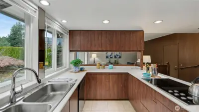 The kitchen offers plenty of prep space and cabinetry, with natural light streaming in through oversized windows.