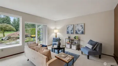 This spacious living room offers a cozy place to unwind while enjoying peaceful views of the surrounding greenery.