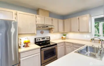 New stove and vent with newer refrigerator, sink and fixtures.