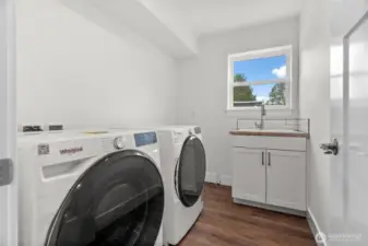 Laundry room featuring a brand new washer and dryer.