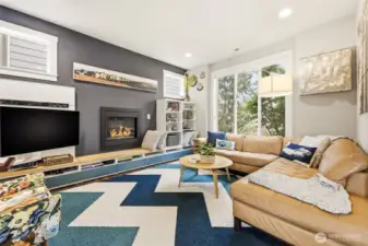Stunning living room with designer paint colors, warm fireplace and cool, built-in shelving system.