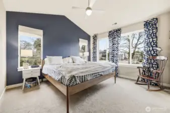 Comfortable bedroom layout with natural light and vaulted ceilings.