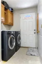 Utility room, door access leads to backside of the house, half bath to the right