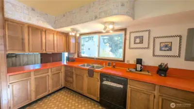 Bright and colorful kitchen with picture window facing the yard.