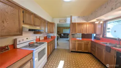 Bright and colorful kitchen with picture window facing the yard.
