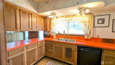 Bright and colorful kitchen with picture window facing the yard.