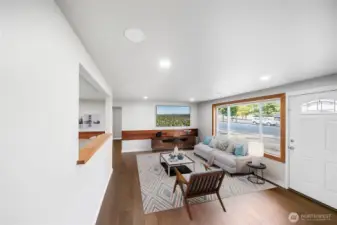 Sunlight pours through the large front window, filling the living room with warmth and brightness. *virtually staged*