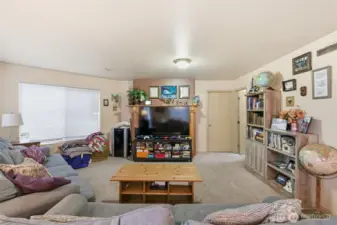 Living room with fireplace behind the tv. Bedroom door to the right
