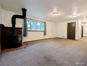 A cozy wood stove for additional winter warmth. The hallway to the right leads to the bedrooms