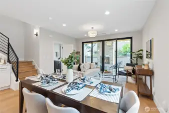 This open concept living and dining area flows effortlessly, creating a welcoming space for entertaining or relaxing. Natural light pours in through expansive glass doors, connecting the indoors to the lush patio and enhancing the home's warm, modern vibe.