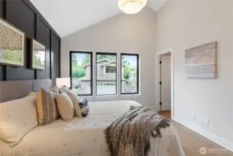 This spacious bedroom combines soft neutrals and bold accents, with a vaulted ceiling and natural light creating a serene, elevated retreat.