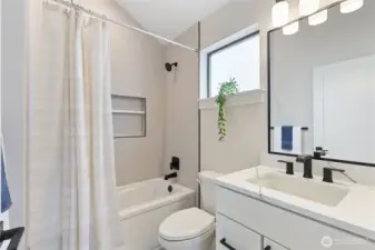 This modern bathroom pairs clean lines with bold black fixtures, offering a fresh, functional space accented by soft neutrals.