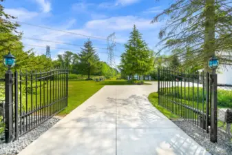 Black iron fencing and coded power gate create an elegant entrance to the property