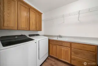 Utility room with sink and plenty of storage. Washing machine is a brand new Samsung and dryer is only 3.